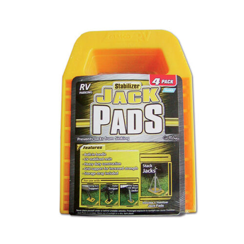 Supporto martinetti Jack Pads in posizione sotto un martinetto di livellamento di un camper, su terreno erboso.