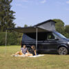 Immagine del F43 Van 300 Deep Black in uso, con persone che si rilassano sotto l'ombra protettiva del tendalino FIAMMA S.P.A..