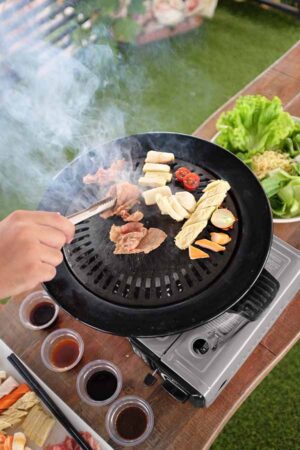 Meat,And,Sausages,On,The,Grill. Immagine della Griglia Devil Grill Plate smontata e riposta, dimostra la sua compattezza e facilità di trasporto per gli accessori outdoor.