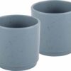 Due tazzine del Set 2 Espresso Dolomit blue posizionate su un tavolo da campeggio.